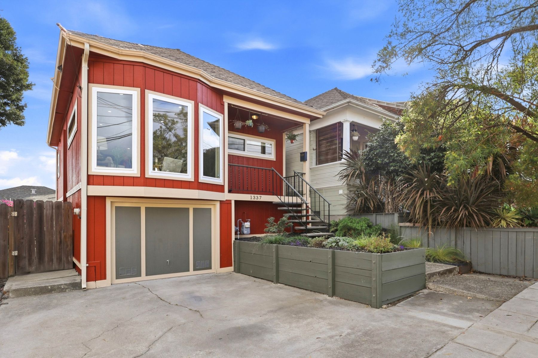 1337 Excelsior Avenue, a red 1910 cottage with a garage below and planter boxes at the entry